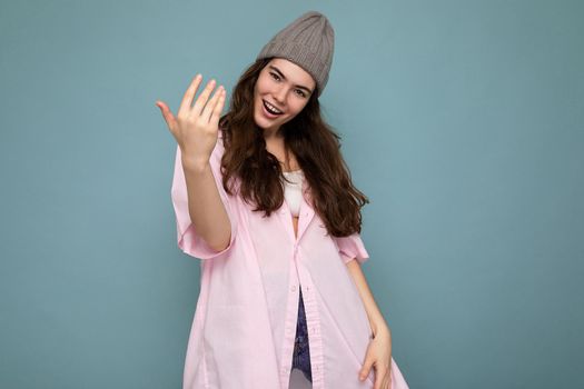 Beautiful positive happy young dark brunette woman isolated over colourful background wall wearing casual stylish clothes feeling sincere emotions looking at camera.