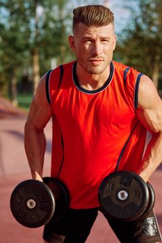 Muscled Man With Dumbbells Outdoor Workout. High quality photo