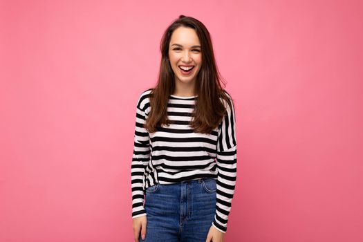 Portrait of positive cheerful fashionable woman in casual clothes isolated on pink background with copy space.