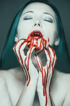 Scary vampire woman, mouth and hands in blood. Halloween or horror theme