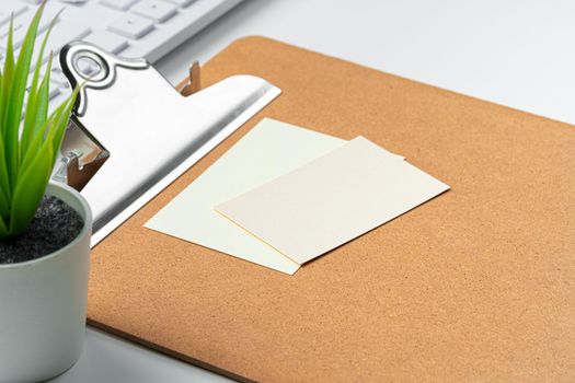 Blank business cards with supplies and keyboard on office table. Close up.