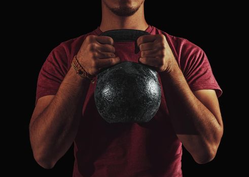Sporty young man exercising with a kettlebell indoor