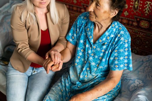Young woman holding senior woman's hand