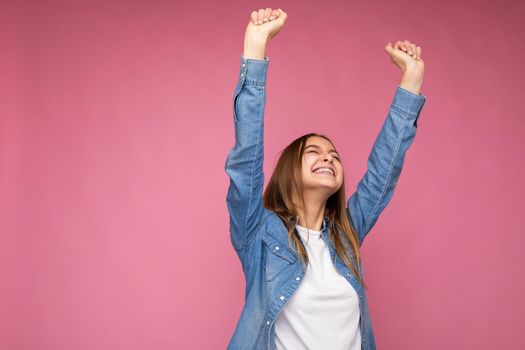 Happy image of Young beautiful dark blonde woman with sincere emotions isolated on background wall with copy space wearing casual white t-shirt for mockup and denim shirt and having fun. Positive concept.