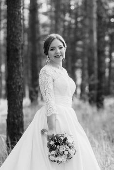 the bride walking in a pine forest on a bright day