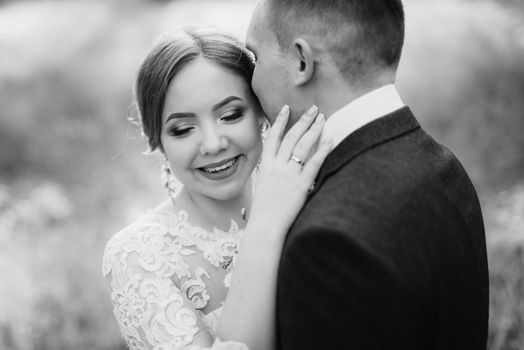 the groom and the bride are walking in the forest near a narrow river on a bright day