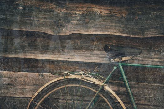 Wheel and seat detail of old bicycle on wooden background, textured vintage image