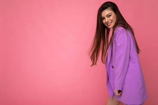 Young happy smiling brunette woman nice-looking attractive charming elegant fashionable wearing stylish suit with jacket isolated over pink background with copy space.