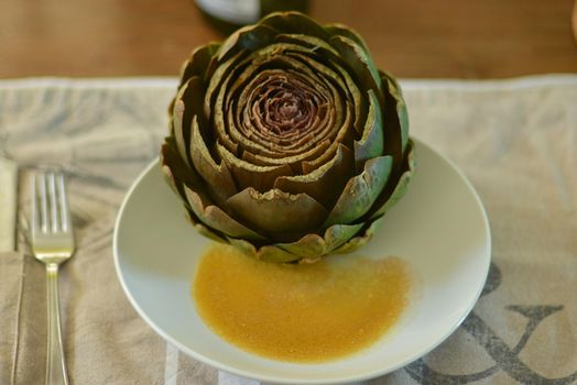 French artichoke on a plate with a sauce vinaigrette