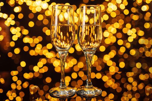 Two glasses of Champagne against shiny bokeh lights background