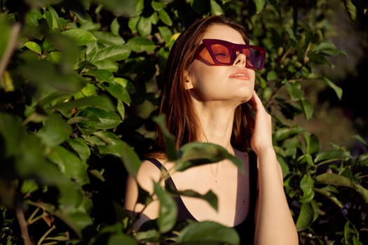 pretty woman wearing sunglasses green leaves glamor posing summer. High quality photo