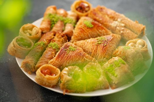 Delicious baklava dessert in oriental setting on black background, close up