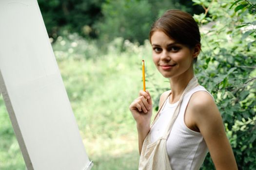 Cheerful woman artist nature easel creative art. High quality photo