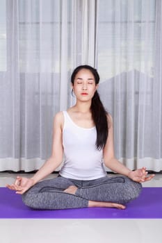 young woman doing yoga exercise isolated on a white background