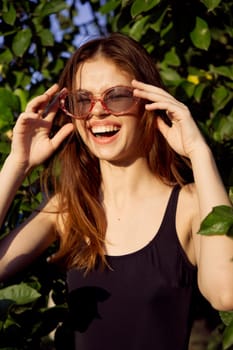 cheerful woman in black swimsuit green leaves nature posing. High quality photo