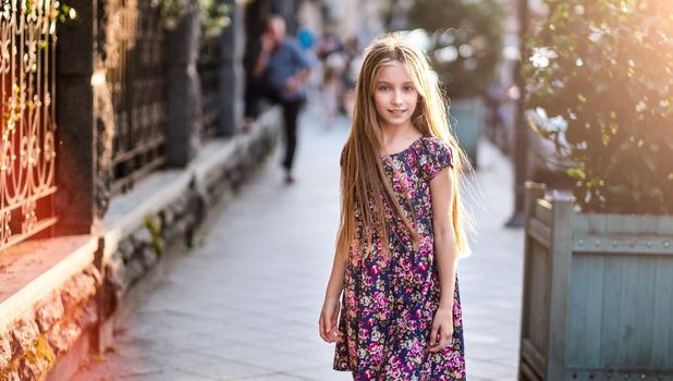 Beautiful little girl on a city street, evening fashion shot