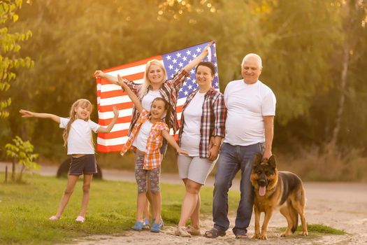 Family Posing Outdoors With American Flag