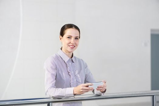 A young woman holds a cell phone. typing in a smartphone.