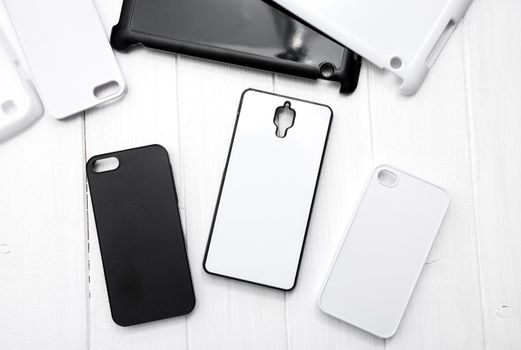 Different monochrome black and white cases for cellphones on the table, topshot