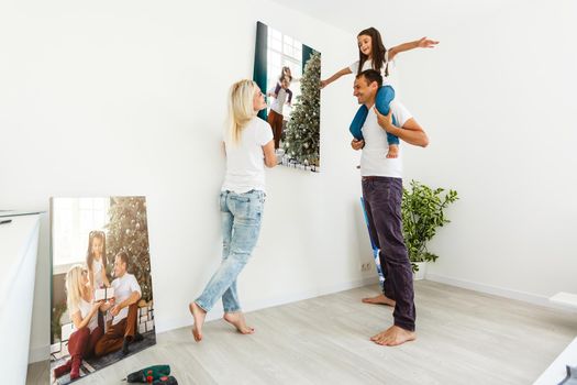 Smiling family holding photo canvas.