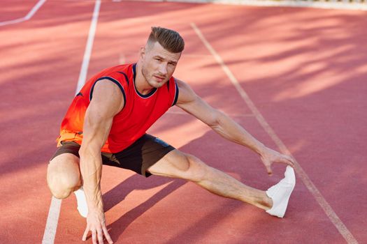 athletic man doing exercises outdoors sports field exercise. High quality photo