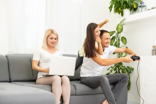 Happy family playing video games at home and having fun together.