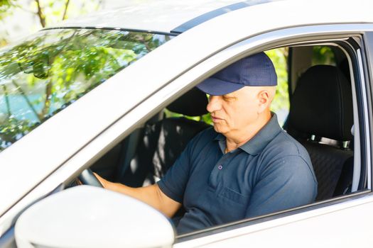 Smiling happy elderly senior man in the new car