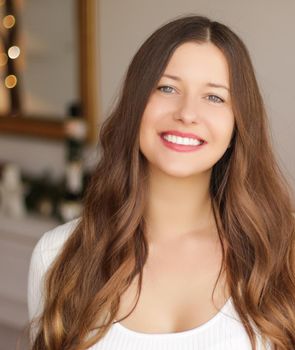 Christmas time and holiday mood concept. Happy smiling woman and decorated xmas tree lights on background.