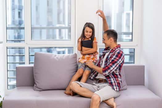 a young father with his little daughter reads the Bible