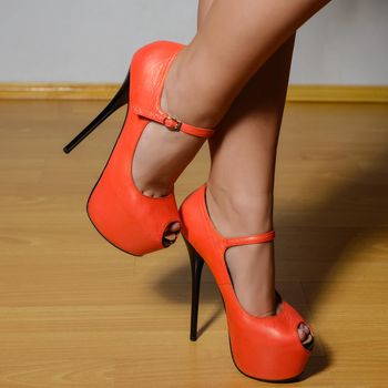 beautiful female legs in stylish red shoes with high heels.
