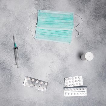 face masks, syringe, medicine pills, vial flatlay. prescription drug for treatment medication top view. Pharmaceutical medicament, cure in container. Injection of covid-19, 2019-nCoV vaccine flat lay