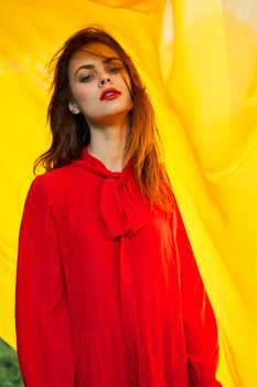 pretty woman in red dress nature yellow cloth on background. High quality photo