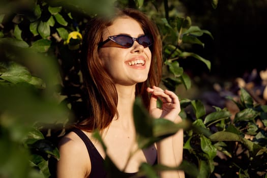 pretty woman wearing sunglasses green leaves posing summer. High quality photo