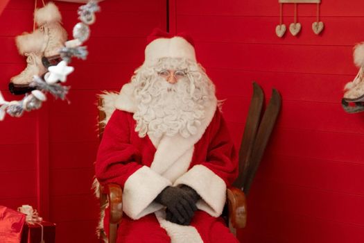 Santa claus is sitting in a armchair in his house