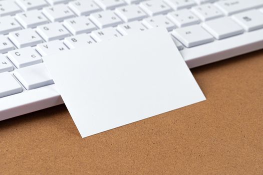 Blank business cards with supplies and keyboard on office table. Close up.