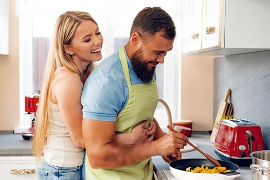 Couple in love preparing meal together in kitchen at home