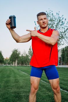 sporty man in the park outdoors glass with drink. High quality photo