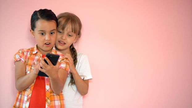 Happy little girls with a smartphone in hands communicate at home with loved ones using modern technology