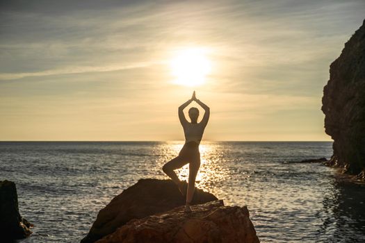 Girl gymnast is training on the beach by the sea sunset. Does twine. Photo series