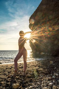 Girl gymnast is training on the beach by the sea sunset. Does twine. Photo series