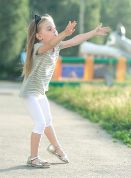 Little happy girl walking on the street