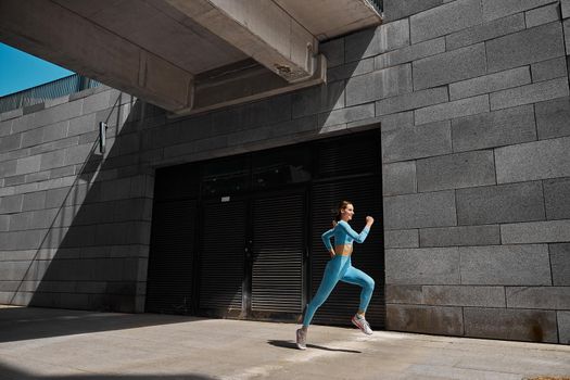 Beautiful fit young woman jogger is running outdoors