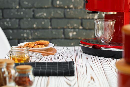 Red coffee machine with a glass on kitchen counter, close up