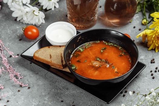 Traditional Ukrainian Russian borscht with white beans on the black bowl. Flat lay. Top view.