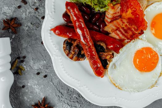 Fried breakfast with bacon, sausages and baked beans.