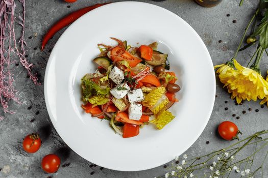 Greek salad with fresh vegetables, feta cheese and black olives.