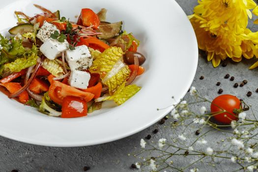 Greek salad with fresh vegetables, feta cheese and black olives.