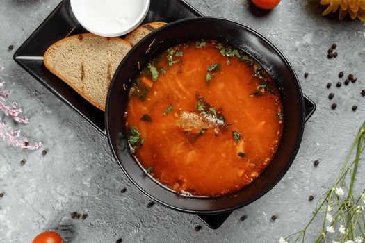 Traditional Ukrainian Russian borscht with white beans on the black bowl. Flat lay. Top view.