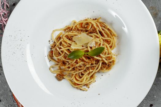 Spaghetti pasta with bolognese sauce and parmesan cheese, top view.