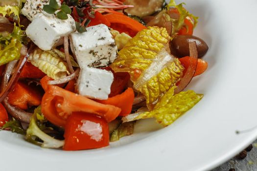 Greek salad with fresh vegetables, feta cheese and black olives.